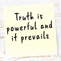 Yellow sticky note with handwritten motivational quote Yellow sticky note with handwritten motivational quote